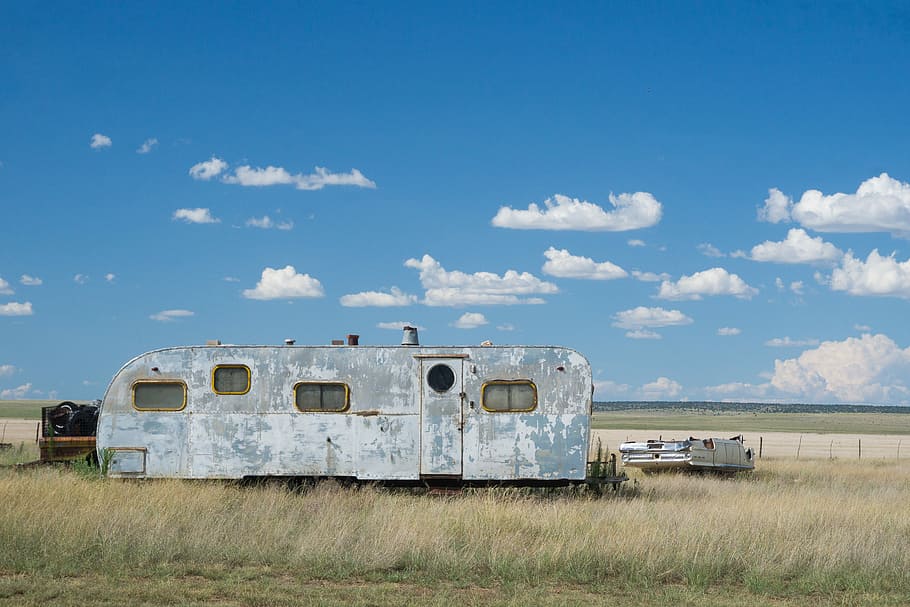 gray metal travel camper on grass land under blue and white cloudy skies at daytime, gray RV trailer on green grass HD wallpaper