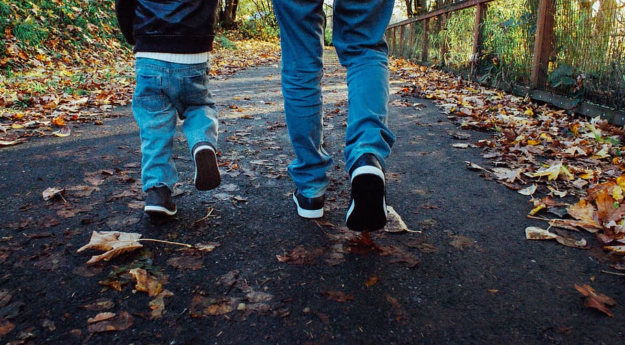 two people waling on road with dried leaves, dad, son, walking