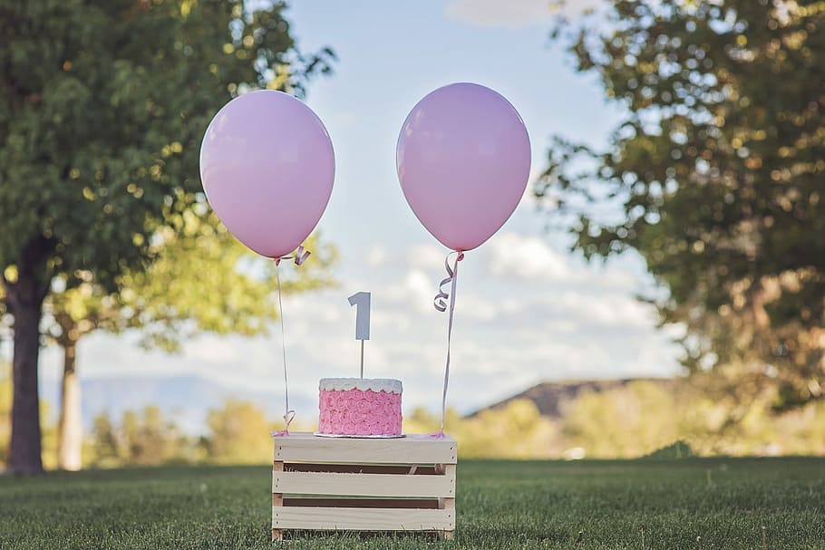 pink cake and balloons on wooden table during daytime, Happy Birthday