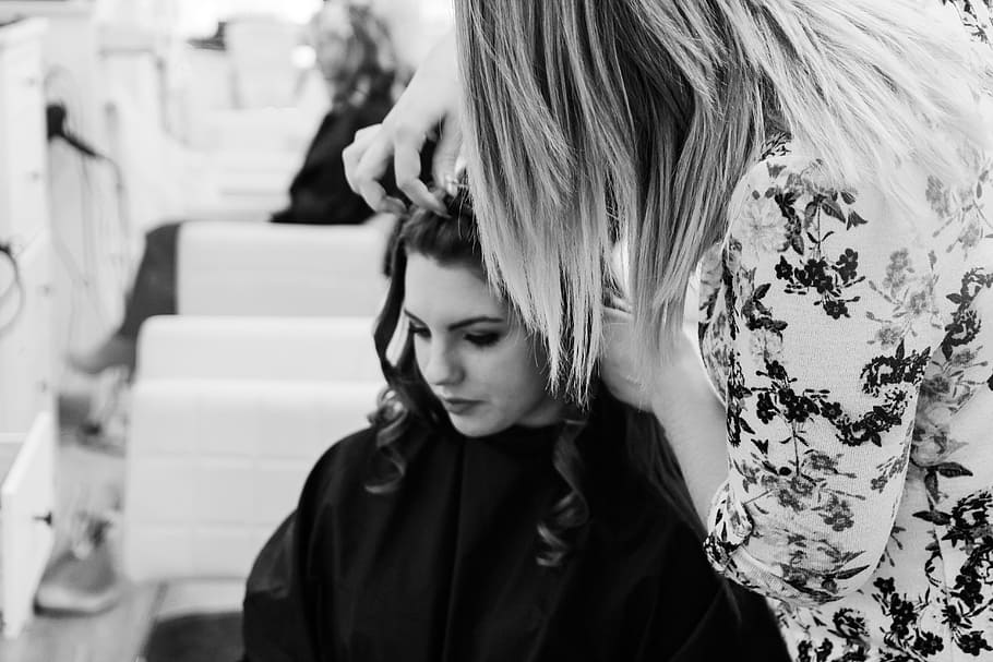 grayscale photography of woman getting her hair done inside salon, grayscale photo of woman arranging hair of woman sitting while looking down HD wallpaper