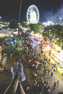 selective focus photo of person wearing sneakers and ferris wheel at distance, person wearing black-and-white Adidas supertstar near ferris wheel and people at night HD wallpaper