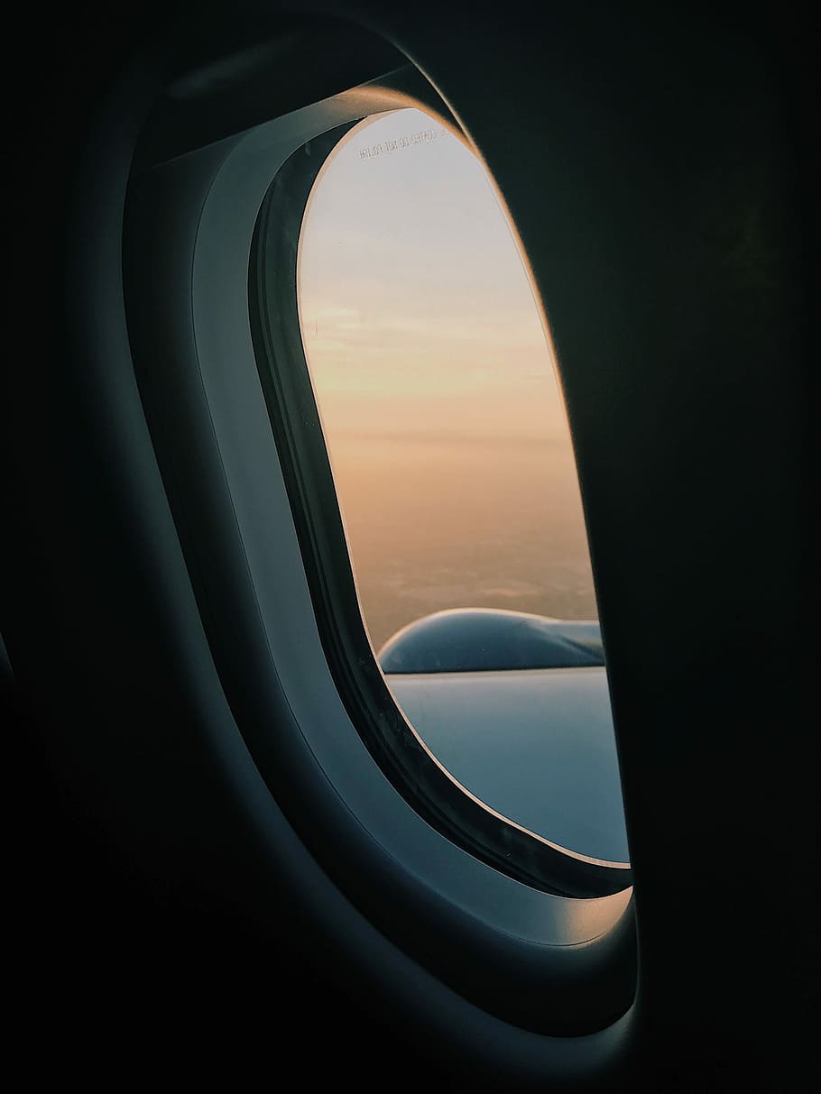 person inside plane at high altitude taking picture of left wing during daytime, airplane window showing sky HD wallpaper