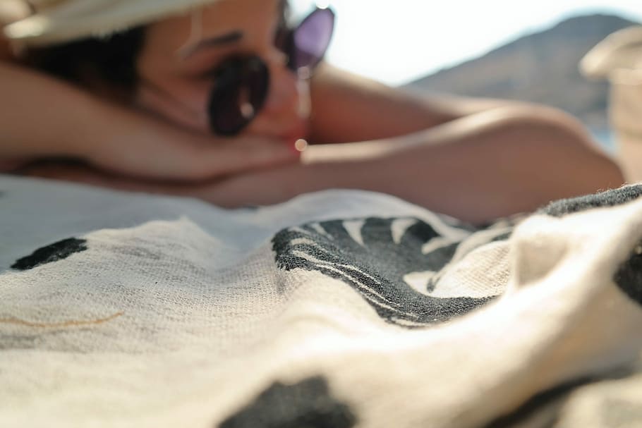 Kissed by the Sun in Greece, woman lying face down on white and black mat HD wallpaper