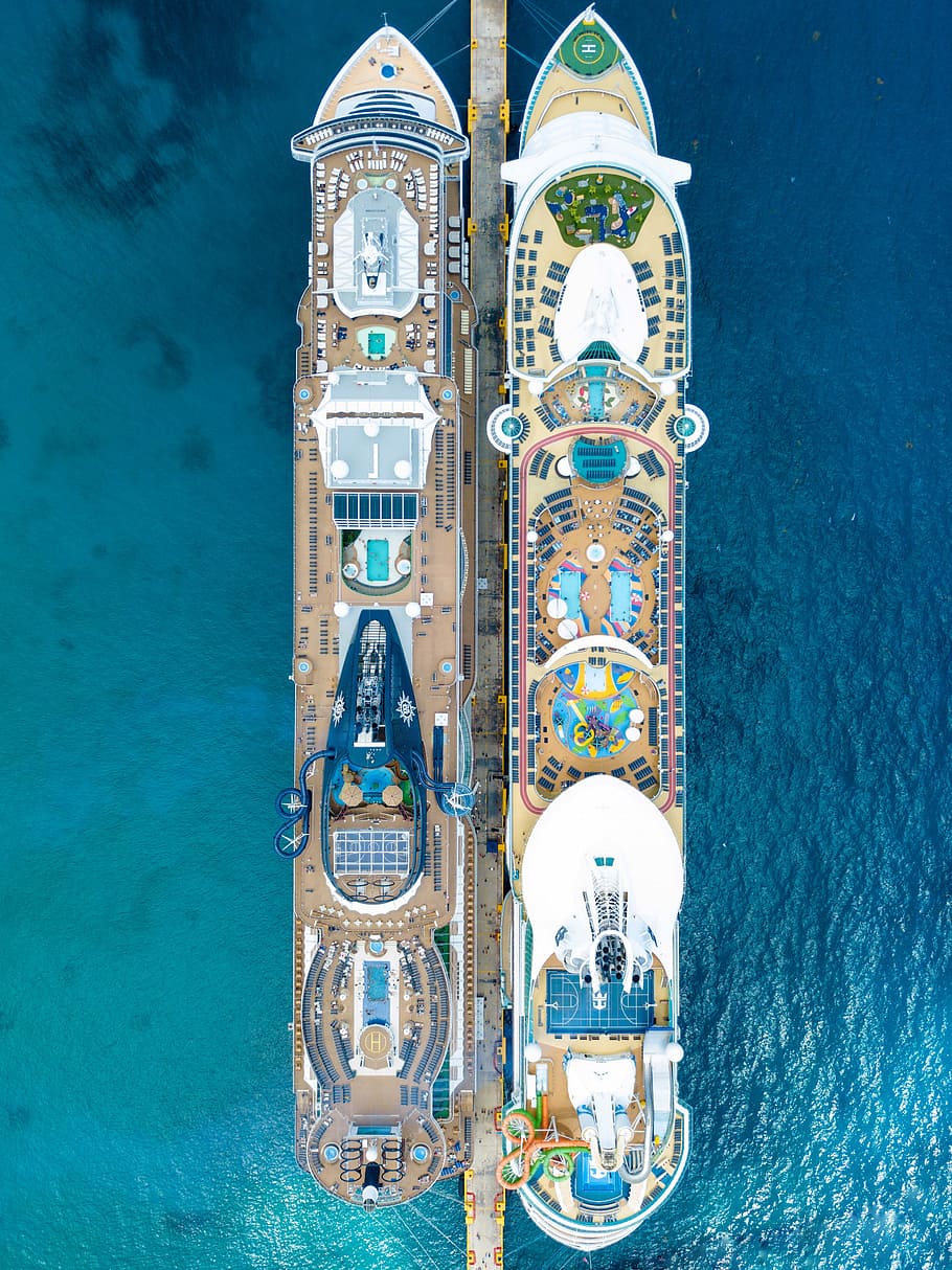 two brown cruise ships on body of water, aerial shot of two cruise ship