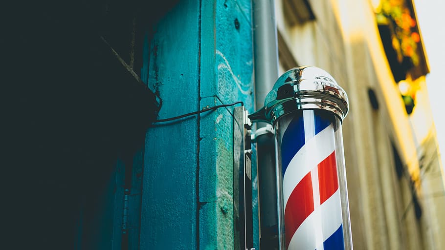 close-up photography of gray stainless steel dispenser, white, red, and blue barber pole