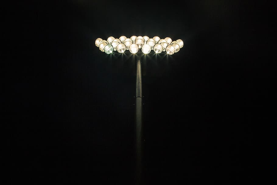 HD wallpaper: Floodlights shining at the top of a light pole with a pitch  black background, untitled | Wallpaper Flare