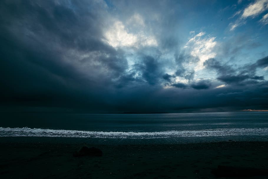 ocean under blue and gray sky, body of water under blue and white sky