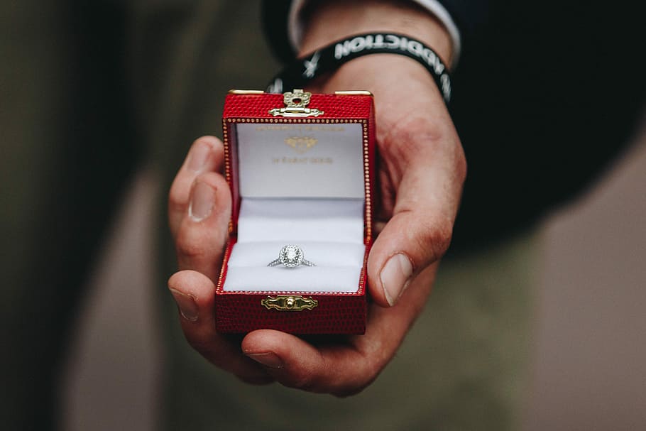 person holding box of silver-colored ring with clear gemstone, closeup photography of person holding clear gemstones silver-colored princess-cut ring in box HD wallpaper