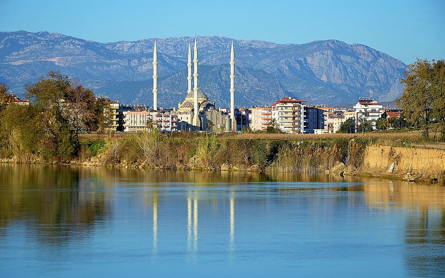 white concrete building surrounded with mountains near body of water at daytime, HD wallpaper