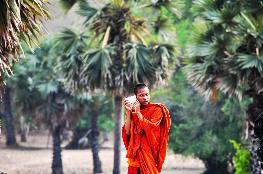 shallow focus photography of man walking, monk holding case near tree, HD wallpaper