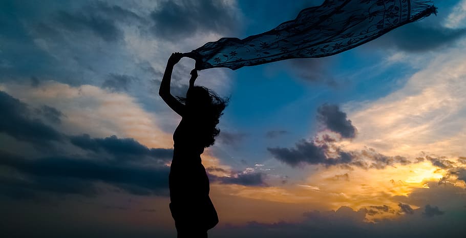 silhouette of woman holding blue dress during sunset, sky, horizon