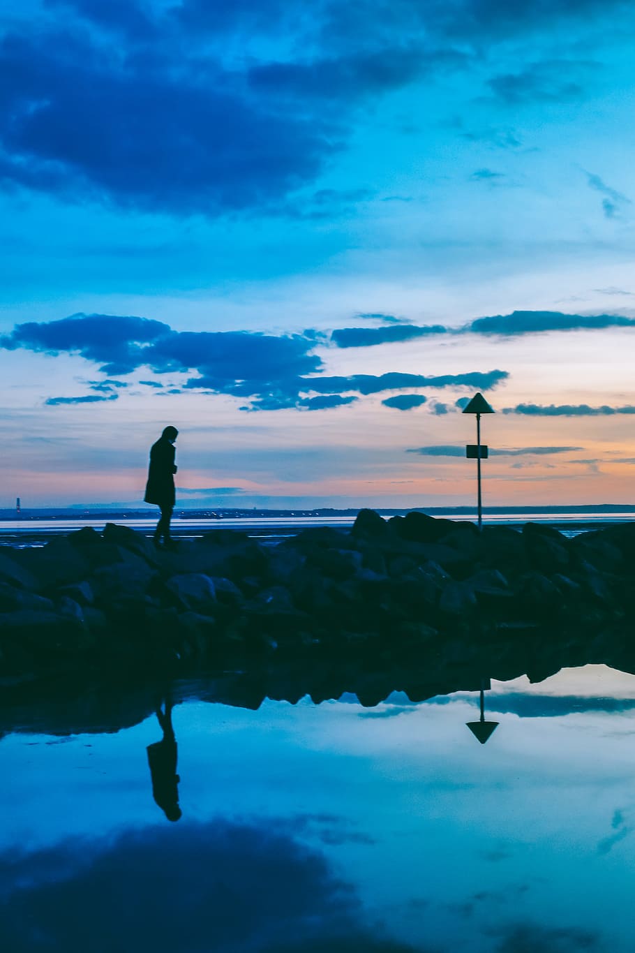 silhouette of person walking on rocks near body of water, silhouette of walking woman on stones near ocean at daytime HD wallpaper