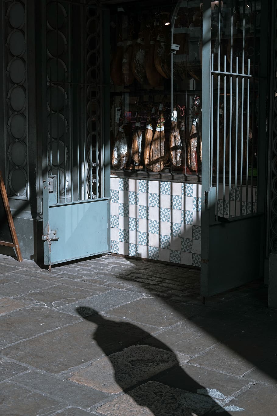 shadow of person standing on gray concrete floor, blue steel double door gate HD wallpaper