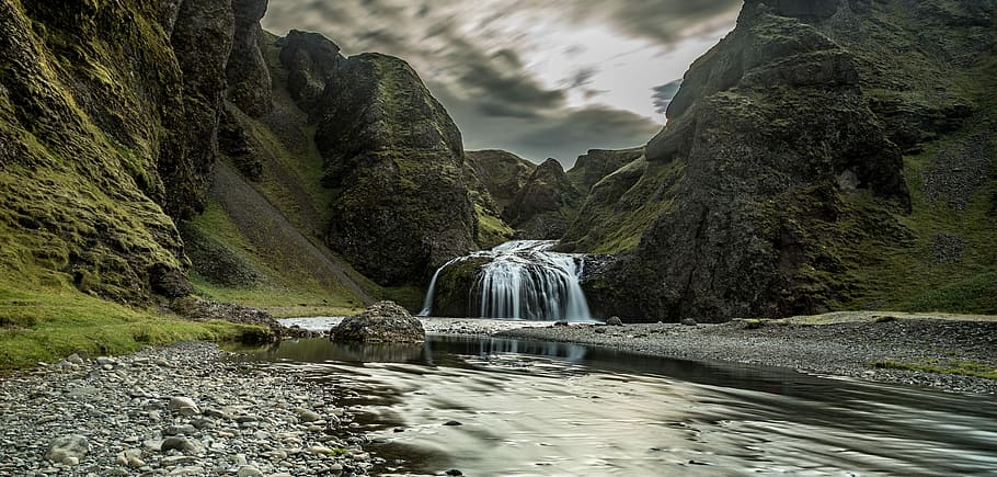 river connected to waterfalls surrounded by mountains under cloudy sky during daytime HD wallpaper