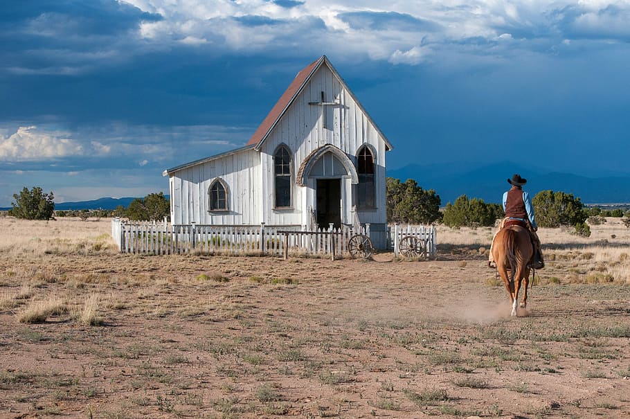 Women riding horse near a small church in Santa Fe, New Mexico