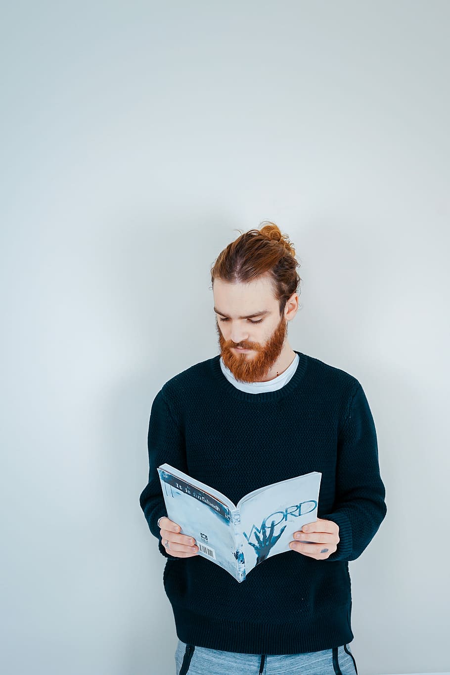 man reading book beside white wall, person holding Word book, HD wallpaper