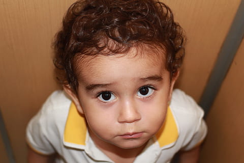 close-up photography of boy in white and yellow polo shirt HD wallpaper
