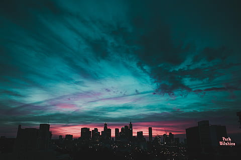 teal sky under city buildings, silhouette of city buildings under teal and pink cloudy sky HD wallpaper