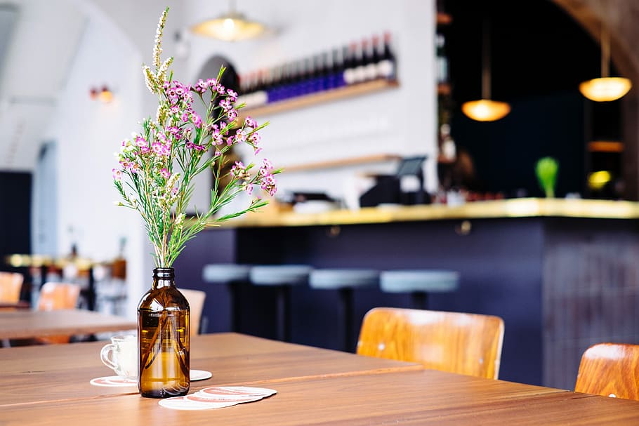 focus photo of pink petaled flower centerpiece on brown wooden table in room HD wallpaper