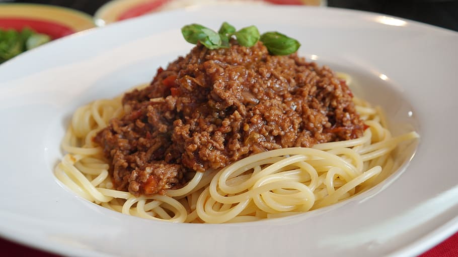 pasta in round white ceramic plate, spaghetti, bolognese, parmesan