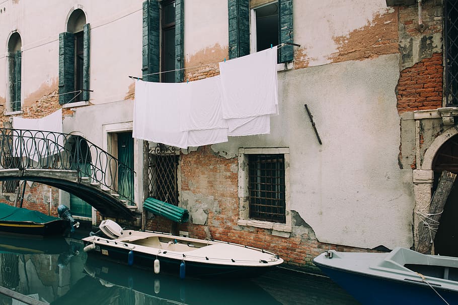 white and blue motorboat near wall during daytime, white boat on body of water beside concrete building HD wallpaper