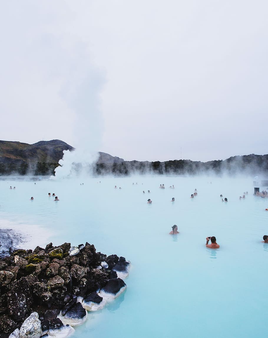 people swimming on hot spring near mountain during daytime, people in blue lagoon, Iceland
