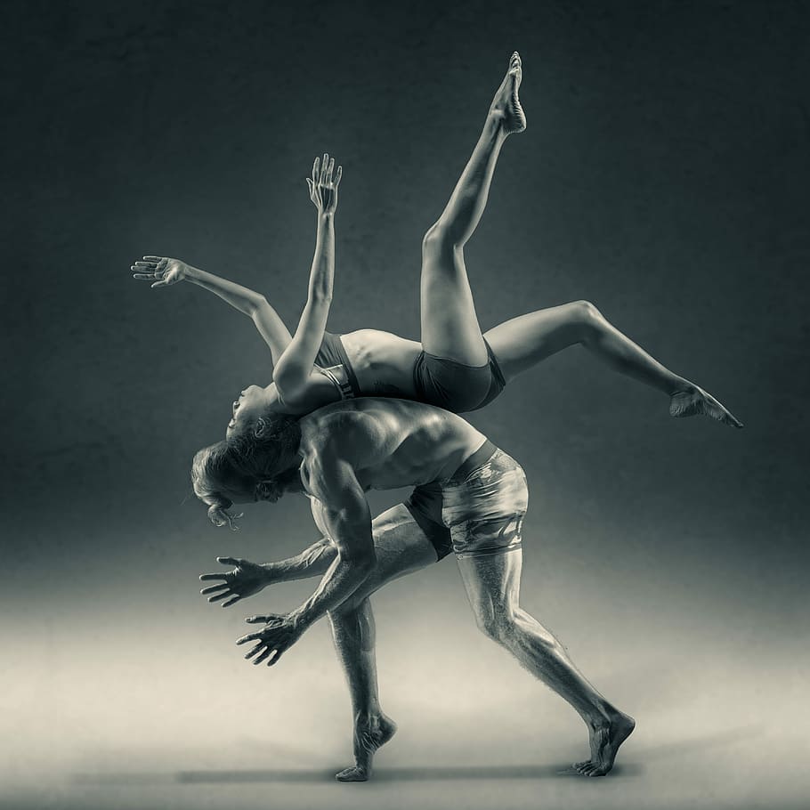 A woman flipping over a man, back to back., photography of woman on man back doing exhibition