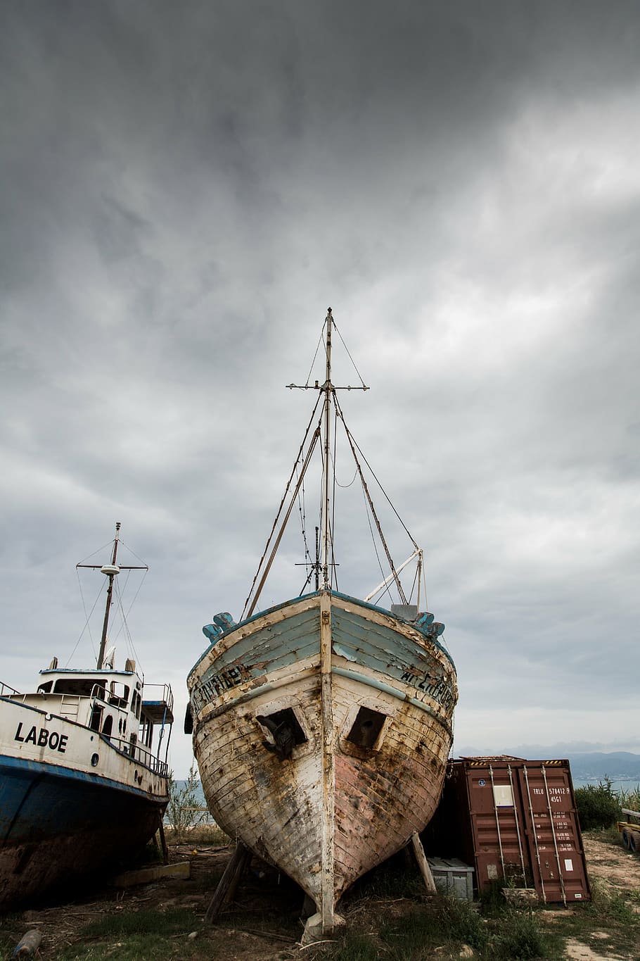 brown and gray abandoned boat near cargo trailer during daytime HD wallpaper