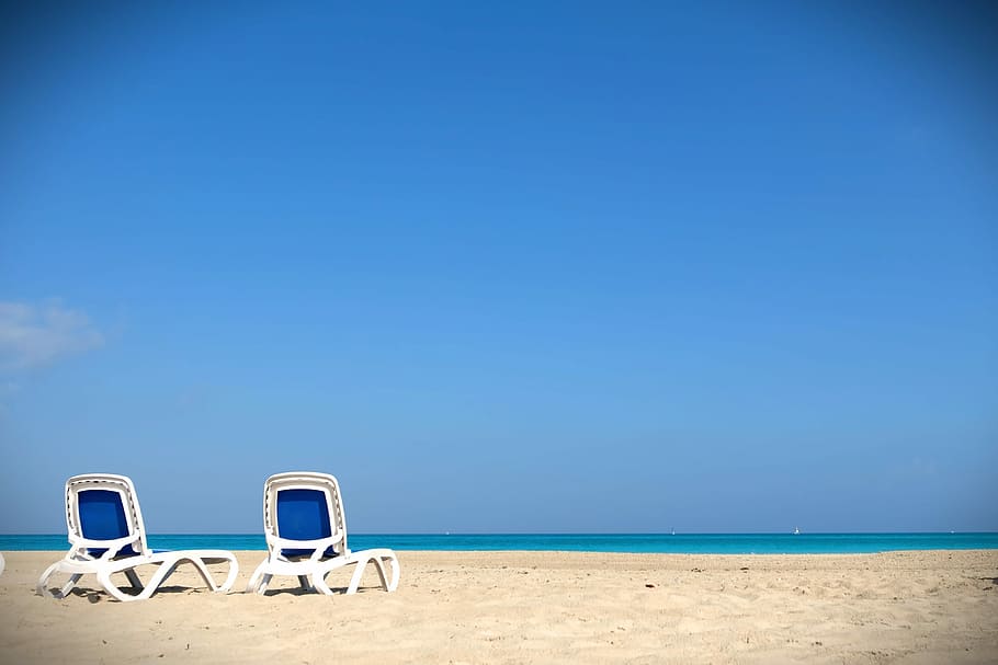 two deckchair on seashore near beach under calming sky, sand