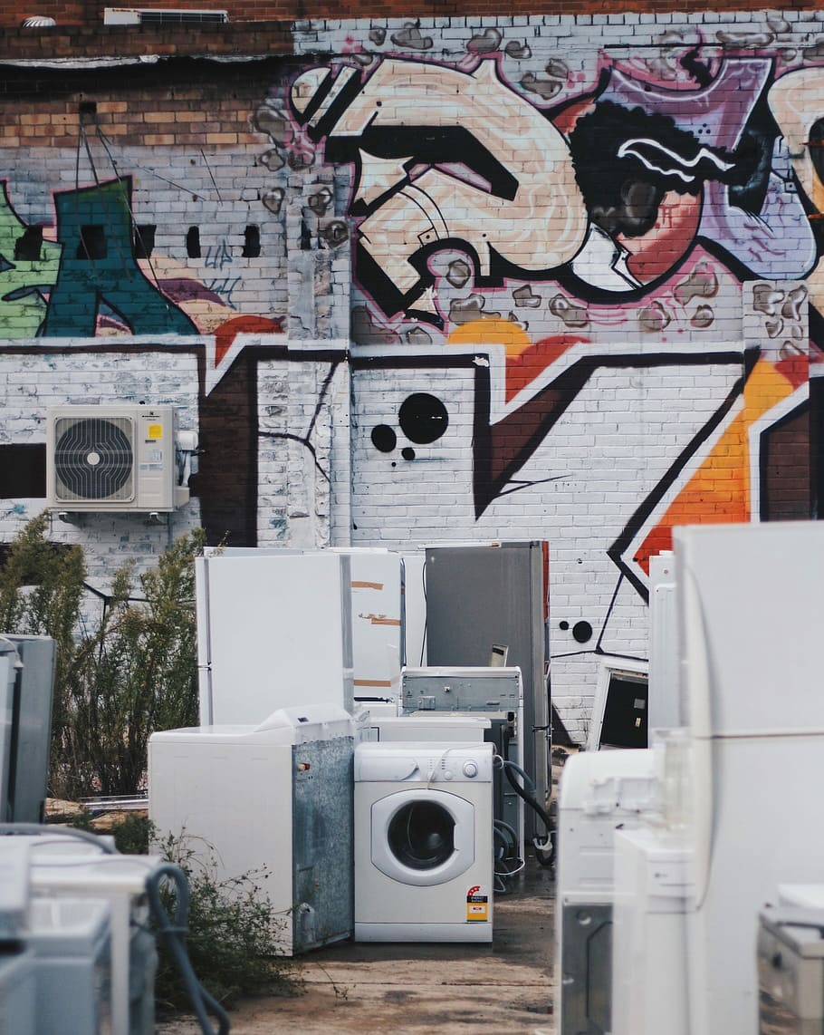 white front-load clothes dryer, home appliance beside graffiti wall