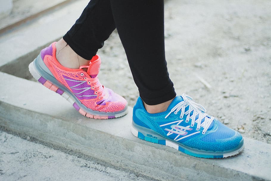 person wearing running shoes, person wearing blue and pink athletic shoes