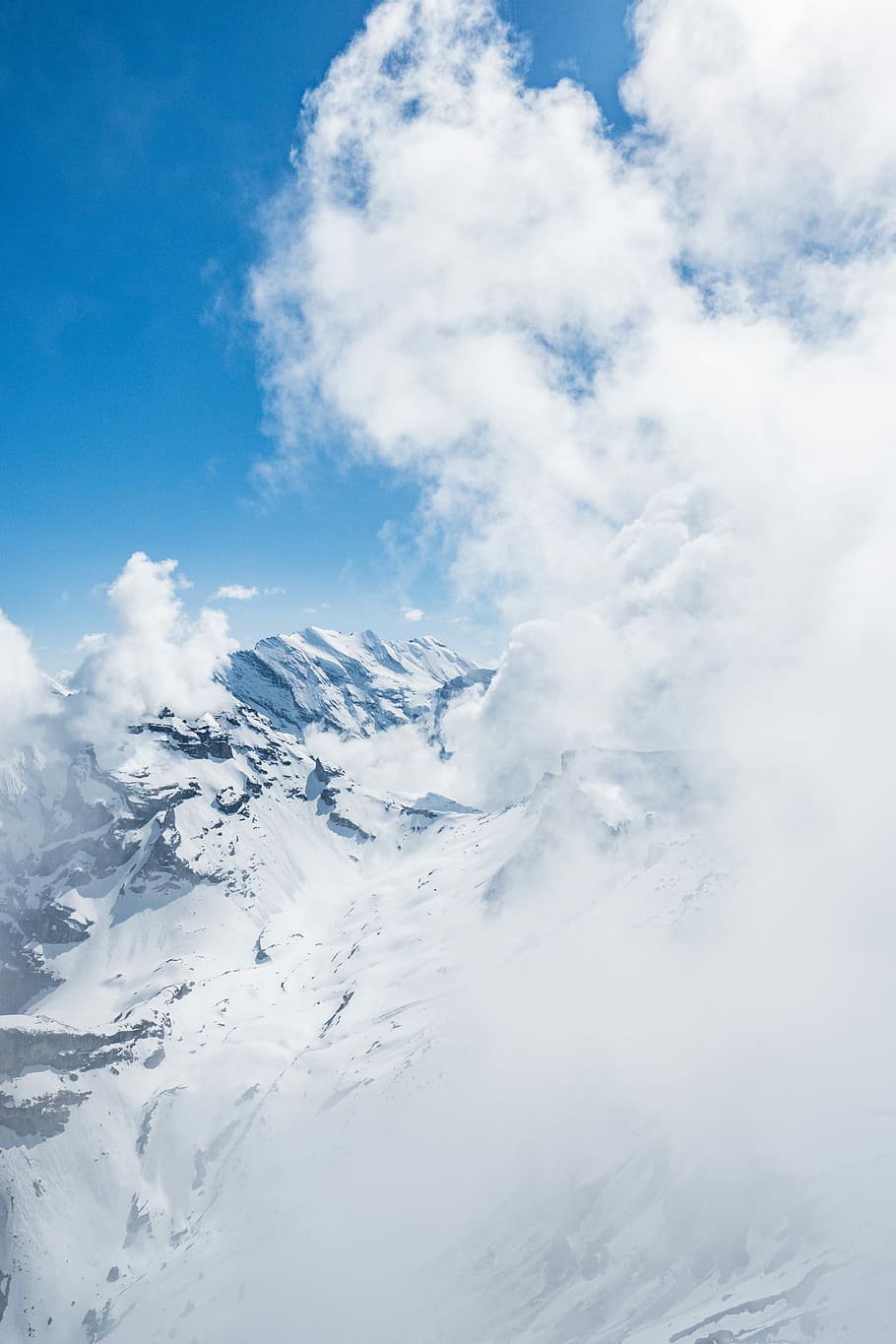Mountain swallowed by clouds, brown mountain covered by snow during daytime HD wallpaper