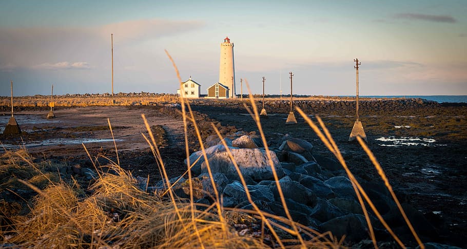 white lighthouse on brown field during daytime, person taking photo of lighthouse HD wallpaper