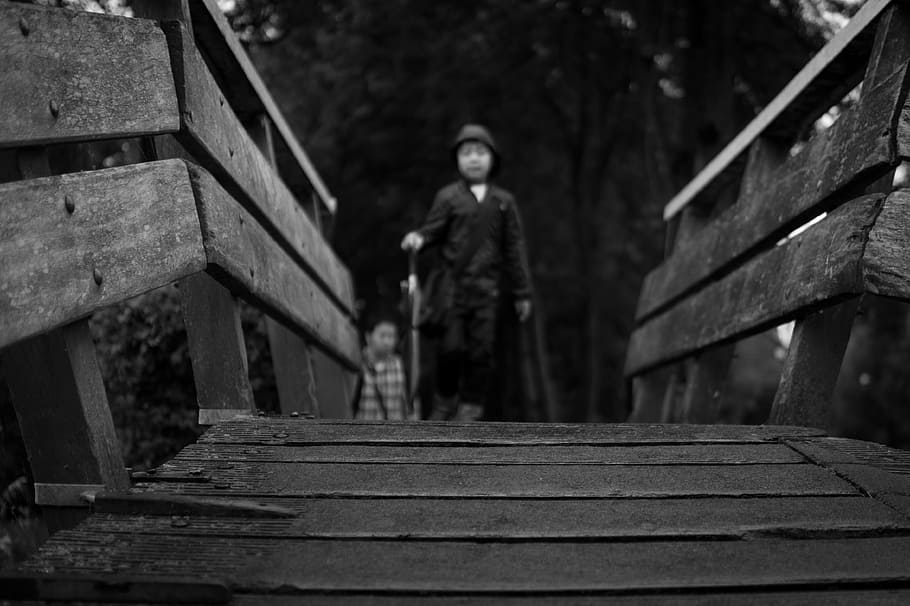 grayscale photo of man walking on bridge, boy, wooden, black and white HD wallpaper