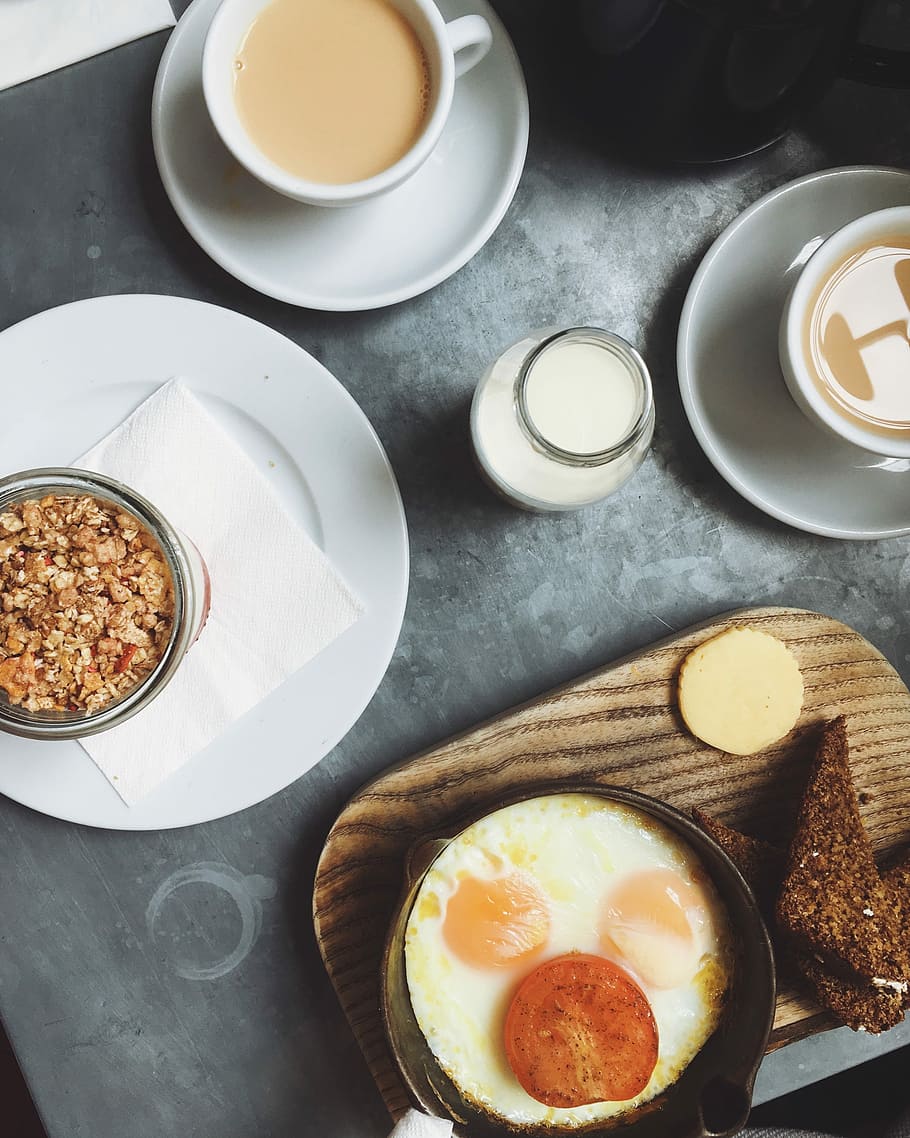 sunny side-up egg on plate beside white plates, breakfast dish on gray surface HD wallpaper