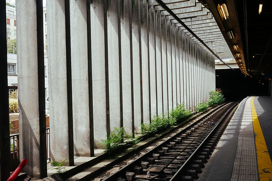 gray concrete road beside train rail, landscape photography of train railway