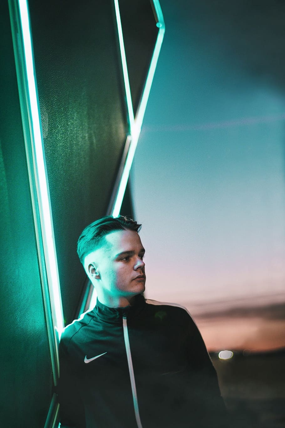 man standing near neon signage, man in black Nike zip-up jacket beside LED lamp HD wallpaper