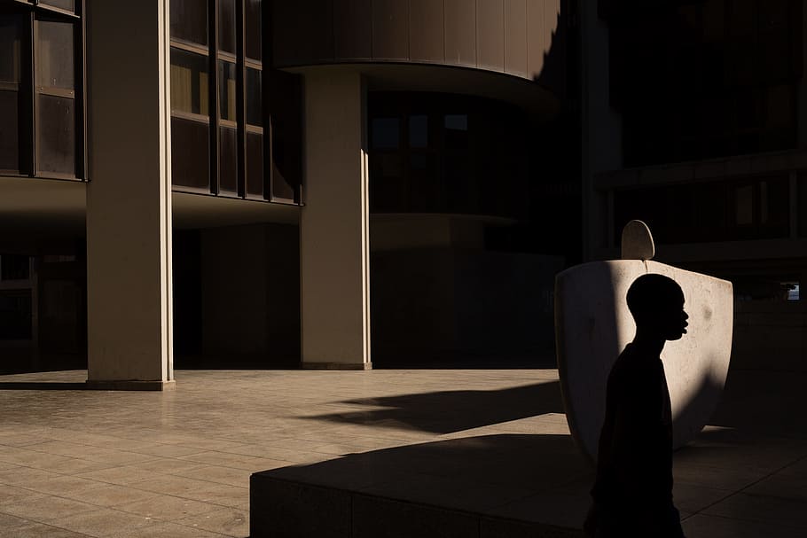 silhouette of a man, silhouette of man walking beside concrete building HD wallpaper