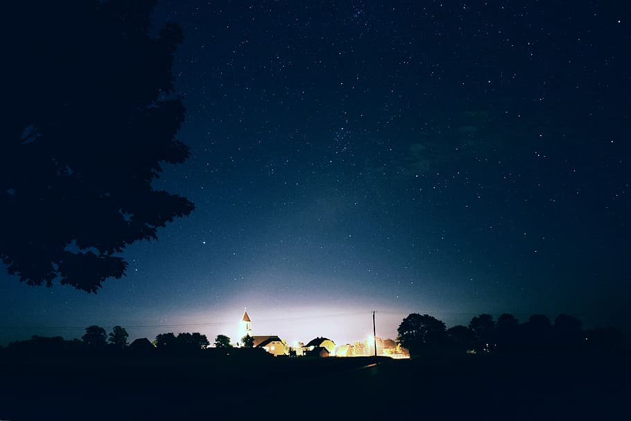 houses and trees under bright stars and sky, brown concrete buildings during nighttime HD wallpaper