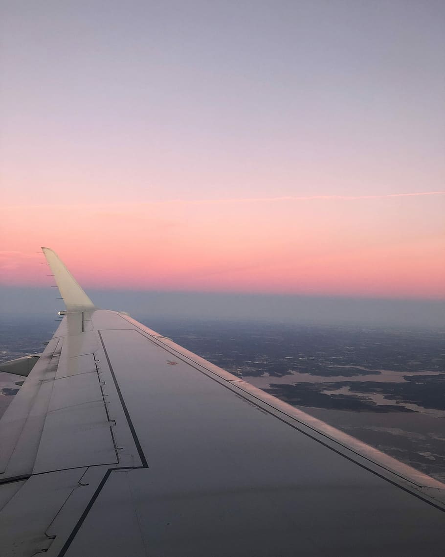 white airplane wing, left airplane wing on flight during golden hour
