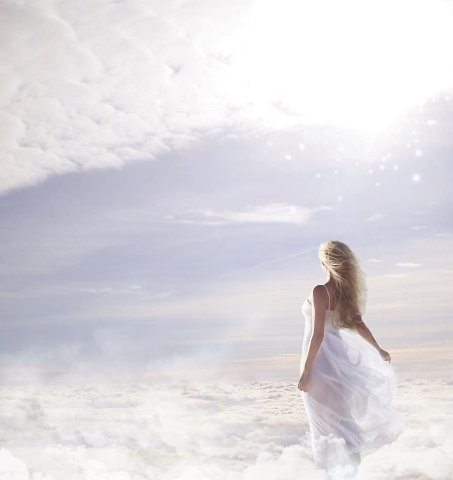 photo of woman in white spaghetti strap dress on clouds, sky