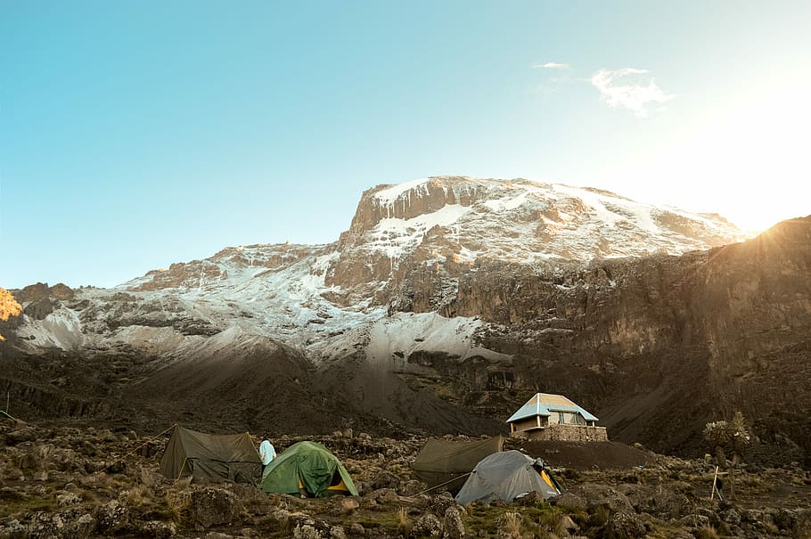 Mount Kilimanjaro, two grey and green tent pitched on rocky road near glacier mountain