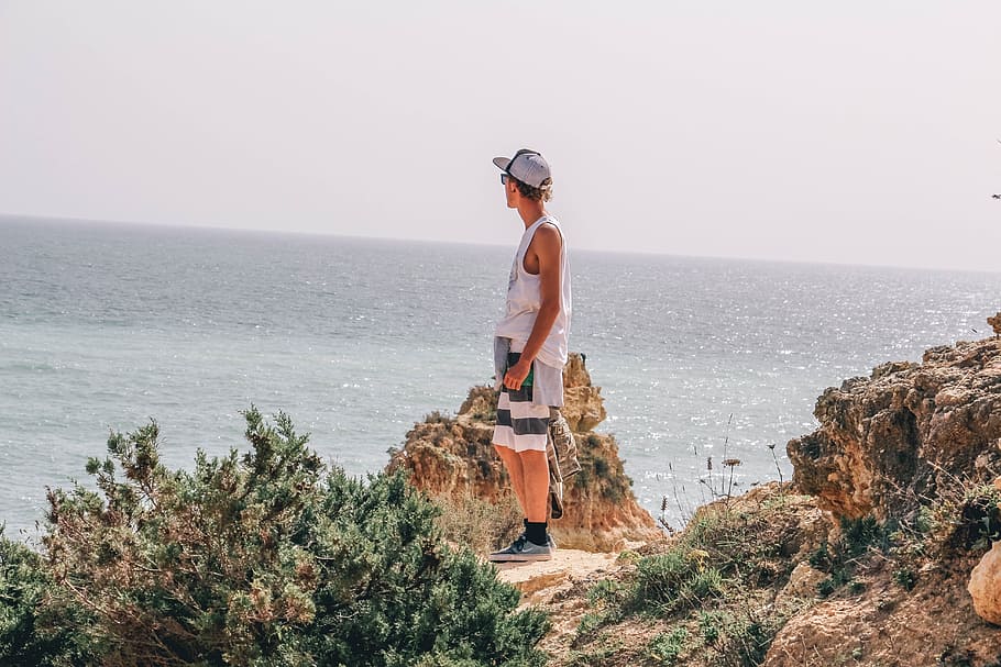 guy, man, hat, ocean, sea, coast, rocks, nature, adventure HD wallpaper