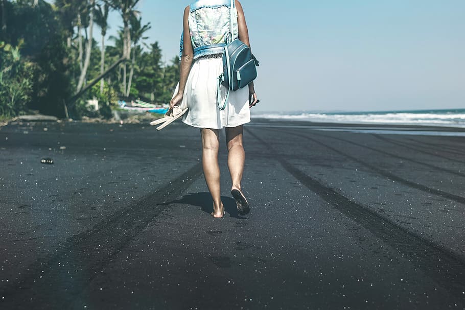 woman walking on the seashore during daytime, Young woman on a black sand beach, Bali island. HD wallpaper