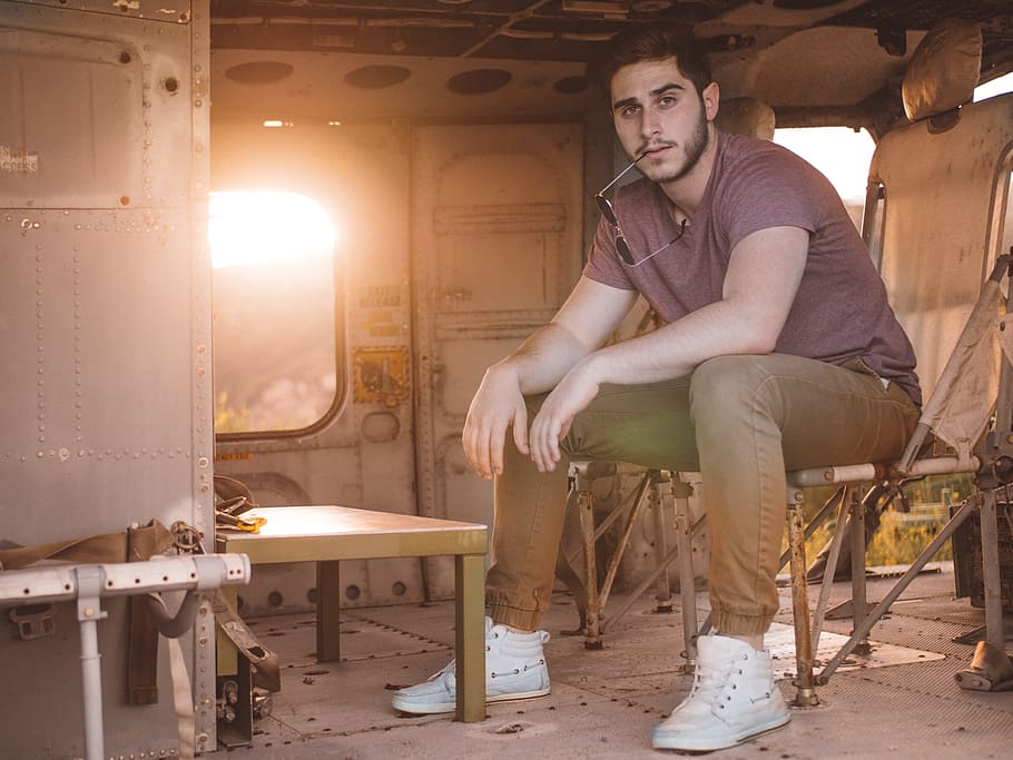 man in gray shirt sitting on brown chair, man wearing purple crew-neck shirt while sitting on brown chair HD wallpaper