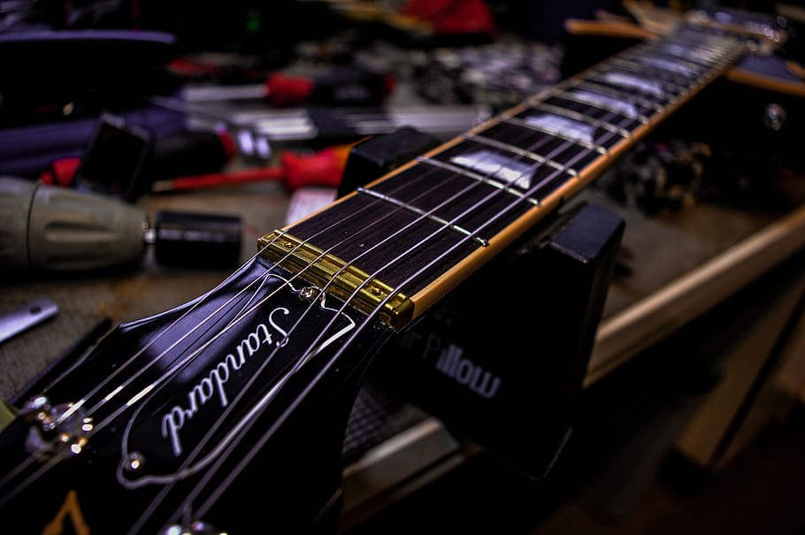 shallow focus photography of black electric guitar headstock