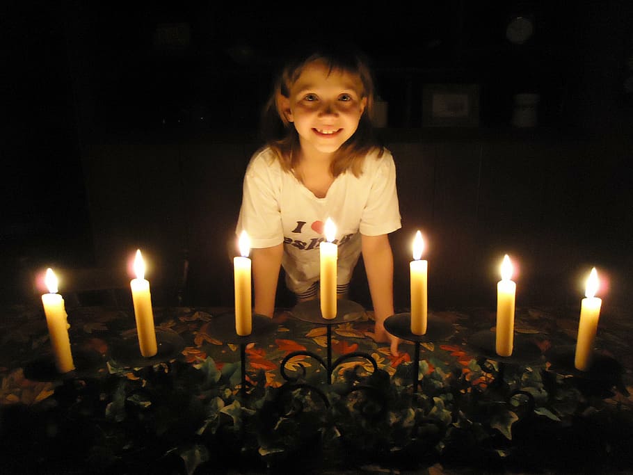 girl standing in front of lit candles, passover, holiday, celebration