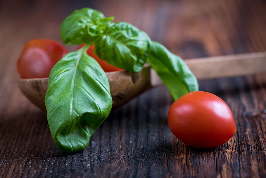 closeup photograph of red tomato on brown wooden surface near ladle with green leaf HD wallpaper
