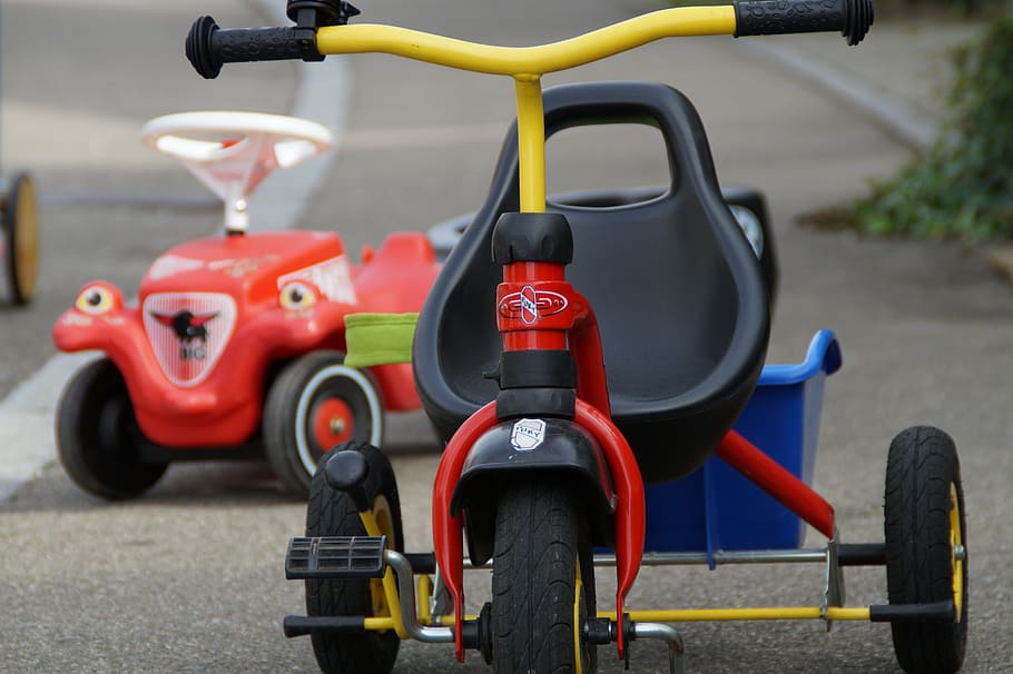 yellow and red trike on road infront of red ride-on toy, children's vehicles, HD wallpaper