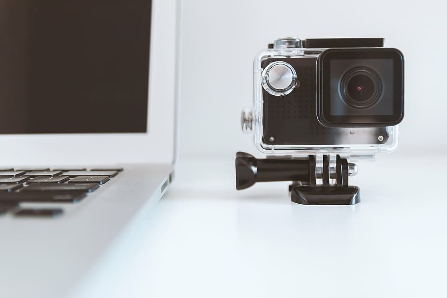 grey and black action camera near white laptop computer, technology HD wallpaper